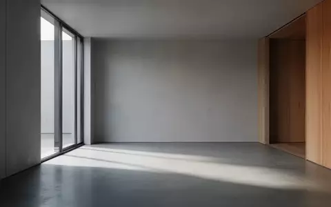 Ein minimalistischer, leerer Raum mit poliertem Betonboden und weichem Tageslicht, das durch ein großes Fenster einfällt. - Foto: über boerse-global.de