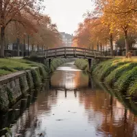 Ein ruhiger Stadtkanal mit einer kleinen Fußgängerbrücke und begrünten Uferbereichen im Spätsommer. - Foto: über boerse-global.de