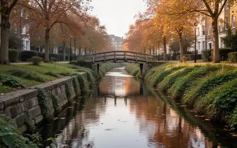 Ein ruhiger Stadtkanal mit einer kleinen Fußgängerbrücke und begrünten Uferbereichen im Spätsommer. - Foto: über boerse-global.de