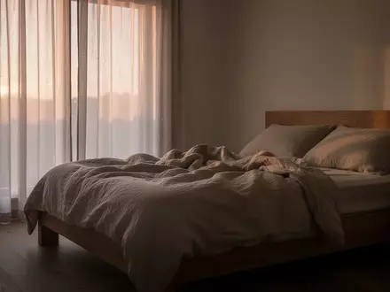 Ein ungemachtes Bett in einem ruhigen Schlafzimmer im sanften Licht der Morgendämmerung. - Foto: über boerse-global.de