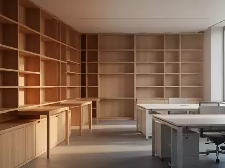 Ein aufgeräumter, minimalistischer Büroraum mit leeren Regalen und Schreibtischen in hellem, natürlichem Licht. - Foto: über boerse-global.de