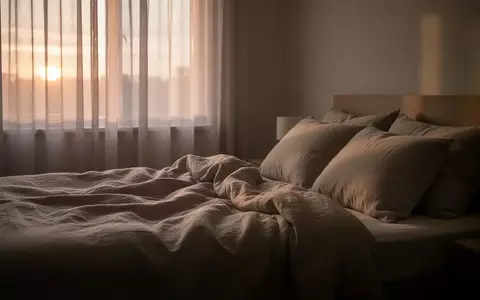 Ein ungemachtes Bett in einem ruhig beleuchteten Schlafzimmer am frühen Morgen, das eine Atmosphäre der Ruhe vermittelt. - Foto: über boerse-global.de