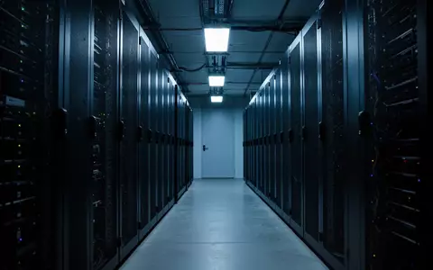 Ein minimalistisch beleuchteter Serverraum mit dunklen SchaltschrĂ€nken in einer industriellen Umgebung. - Foto: ĂŒber boerse-global.de
