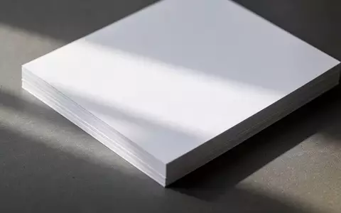 Ein Stapel weißer Papierbögen auf einer dunklen, strukturierten Oberfläche in natürlichem Licht. - Foto: über boerse-global.de