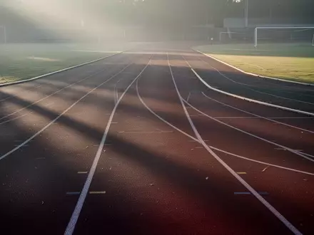 Eine leere Laufbahn im frühen Morgenlicht, die Ruhe und Erholung nach sportlicher Anstrengung symbolisiert. - Foto: über boerse-global.de