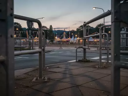 Leere Straße bei Dämmerung nahe des Wasengeländes in Stuttgart mit Metallgeländern und Betonboden. - Foto: über boerse-global.de
