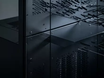Ein dunkler, metallischer Serverschrank in einem ruhig beleuchteten Raum mit Fokus auf industrielle Texturen und Schatten. - Foto: ĂĽber boerse-global.de