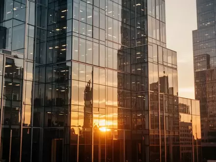 Moderne Glasfassade eines Bürogebäudes im Finanzviertel bei Sonnenuntergang. - Foto: über boerse-global.de