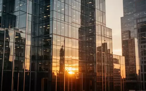 Moderne Glasfassade eines Bürogebäudes im Finanzviertel bei Sonnenuntergang. - Foto: über boerse-global.de