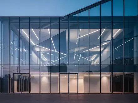 Moderne Glasfassade eines Bürogebäudes in der Abenddämmerung mit geometrischen Reflexionen. - Foto: über boerse-global.de