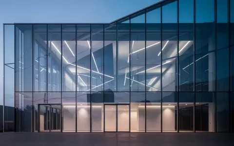 Moderne Glasfassade eines Bürogebäudes in der Abenddämmerung mit geometrischen Reflexionen. - Foto: über boerse-global.de