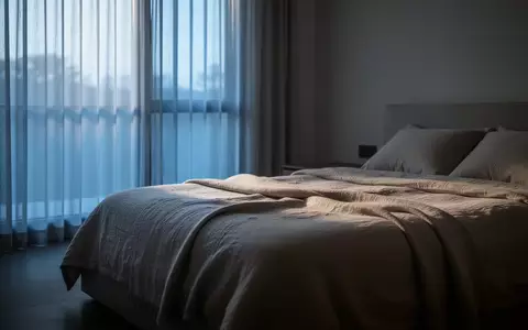 Ein ruhiges, in sanftes Morgenlicht getauchtes Schlafzimmer mit einem ordentlich gemachten Bett in minimalistischer Umgebung. - Foto: über boerse-global.de
