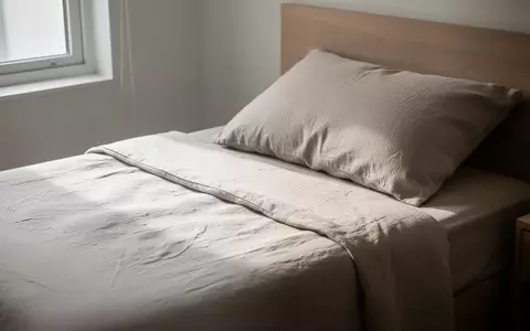 Ein ordentlich gemachtes Bett in einem hellen, ruhig eingerichteten Schlafzimmer mit einfallendem Tageslicht. - Foto: über boerse-global.de