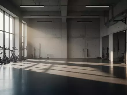 Ein minimalistischer, leerer Fitnessraum mit Betonwänden und einfallendem Tageslicht. - Foto: über boerse-global.de