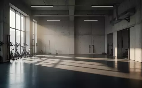 Ein minimalistischer, leerer Fitnessraum mit Betonwänden und einfallendem Tageslicht. - Foto: über boerse-global.de