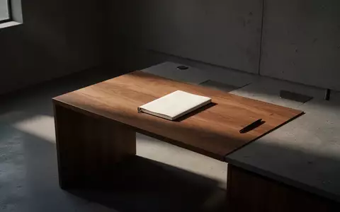 Ein minimalistischer, schattiger Arbeitsraum mit einem leeren Notizbuch auf einem Schreibtisch aus Holz. - Foto: über boerse-global.de