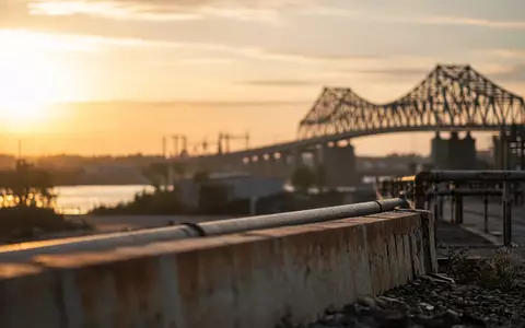 Moderne Brückenkonstruktion in einer industriellen Landschaft bei Sonnenuntergang. - Foto: über boerse-global.de