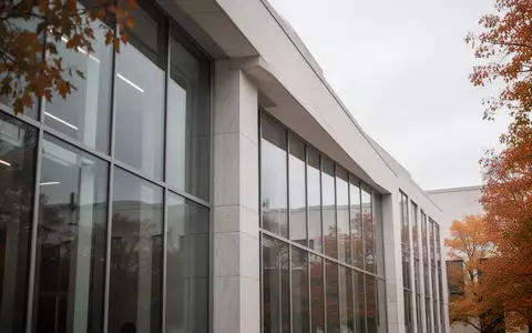 Moderne Fassade eines Regierungsgebäudes bei bewölktem Himmel mit Fokus auf architektonische Linien. - Foto: über boerse-global.de