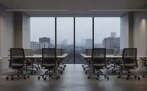 Ein minimalistisch gestalteter, leerer Büroarbeitsbereich mit großen Fensterfronten und Blick auf eine städtische Skyline. - Foto: über boerse-global.de