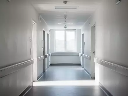 Ein leerer, modern gestalteter Krankenhausflur mit minimalistischer Architektur und hellem Tageslicht. - Foto: über boerse-global.de