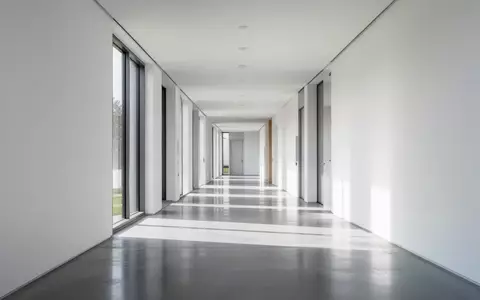 Ein minimalistischer Flur in einem Verwaltungsgebäude mit poliertem Betonboden und hellem Tageslicht. - Foto: über boerse-global.de