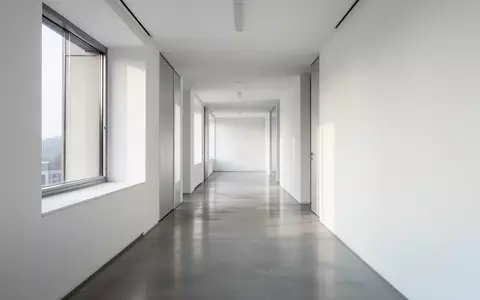 Ein leerer, modern gestalteter Büroflur mit klaren architektonischen Linien und hellem Tageslicht. - Foto: über boerse-global.de
