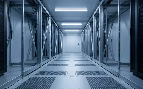 Ein minimalistischer, modern beleuchteter Serverraum-Flur mit kühler blauer Beleuchtung und architektonischen Linien. - Foto: über boerse-global.de