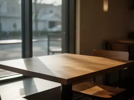 Ein leerer Holztisch in einem ruhigen Café bei natürlichem Lichteinfall. - Foto: über boerse-global.de