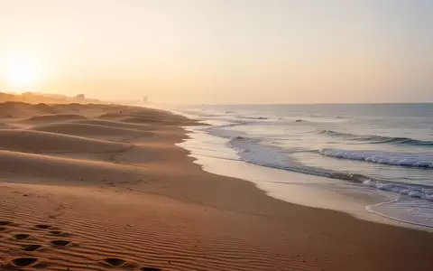 Ruhiger Sandstrand am Haeundae Beach bei Sonnenuntergang mit sanften Wellen und stimmungsvollem Abendlicht. - Foto: über boerse-global.de