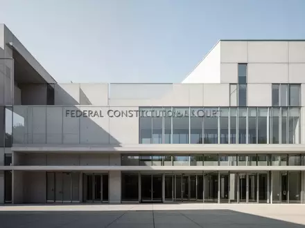 Die minimalistische Beton- und Glasfassade des Bundesverfassungsgerichts in Karlsruhe unter klarem Himmel. - Foto: über boerse-global.de