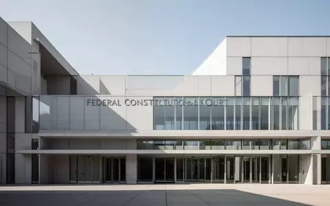 Die minimalistische Beton- und Glasfassade des Bundesverfassungsgerichts in Karlsruhe unter klarem Himmel. - Foto: über boerse-global.de
