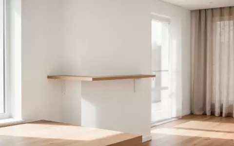 Ein minimalistischer, heller Wohnraum mit einem leeren Holzregal an einer weißen Wand, der Ordnung und Struktur symbolisiert. - Foto: über boerse-global.de