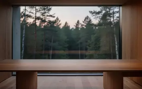 Ein minimalistischer, leerer Schreibtisch in einem hellen Arbeitszimmer mit Blick auf einen Wald bei Dämmerung. - Foto: über boerse-global.de