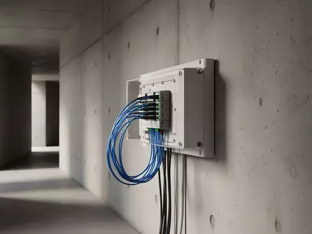 Ein moderner Glasfaser-Anschlusskasten an einer schlichten Betonwand in einem minimalistisch gestalteten Flur. - Foto: über boerse-global.de