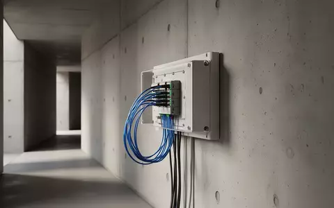 Ein moderner Glasfaser-Anschlusskasten an einer schlichten Betonwand in einem minimalistisch gestalteten Flur. - Foto: über boerse-global.de