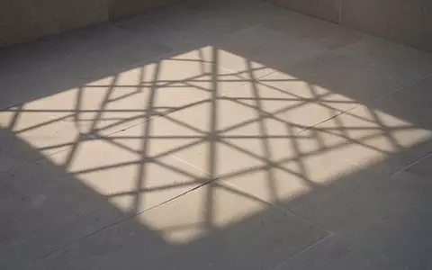 Ein abstraktes, geometrisches Rastermuster auf einer neutralen Steinoberfläche bei sanftem Morgenlicht. - Foto: über boerse-global.de