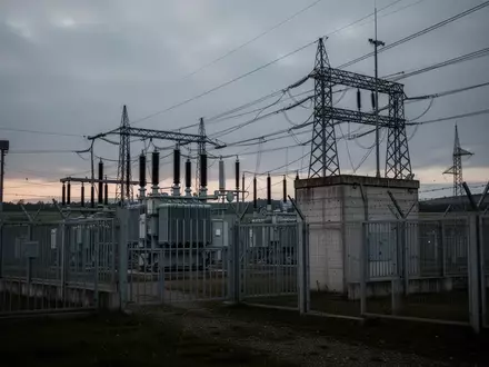 Ein Hochspannungstransformatorwerk mit Sicherheitszäunen in einer Industrielandschaft bei Dämmerung. - Foto: über boerse-global.de