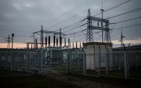 Ein Hochspannungstransformatorwerk mit Sicherheitszäunen in einer Industrielandschaft bei Dämmerung. - Foto: über boerse-global.de