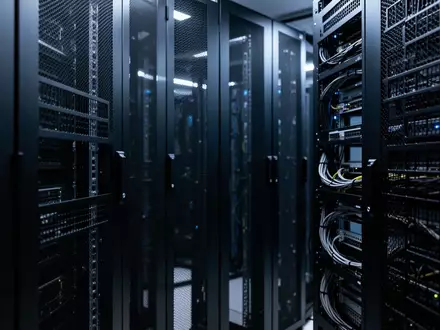 Reihen von dunklen, modernen Server-Racks in einem minimalistisch beleuchteten Rechenzentrum. - Foto: über boerse-global.de