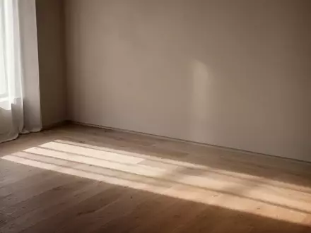 Ein minimalistischer, lichtdurchfluteter Raum mit weichen Schatten auf einer Holzwand als Symbol für den Lebensverlauf. - Foto: über boerse-global.de