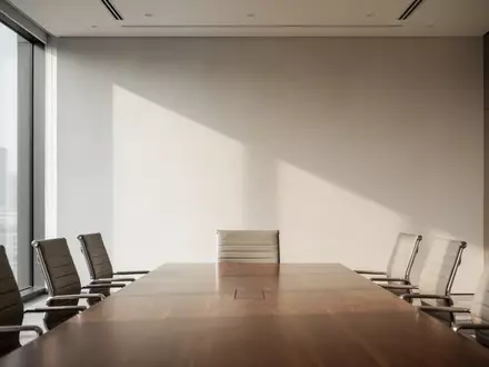 Ein minimalistischer, lichtdurchfluteter Konferenzraum mit einem leeren Holztisch und einer klaren architektonischen Struktur. - Foto: über boerse-global.de