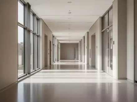 Ein minimalistischer, leerer Flur in einem modernen Verwaltungsgebäude mit hellem Tageslicht und schlichten Oberflächen. - Foto: über boerse-global.de