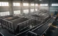 Innenansicht einer modernen industriellen Recyclinganlage mit leeren Sortierbehältern und Förderbändern in natürlichem Licht. - Foto: über boerse-global.de