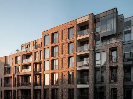 Fassade eines modernen Wohnblocks in einer deutschen Stadt im warmen Licht der Abendsonne. - Foto: über boerse-global.de