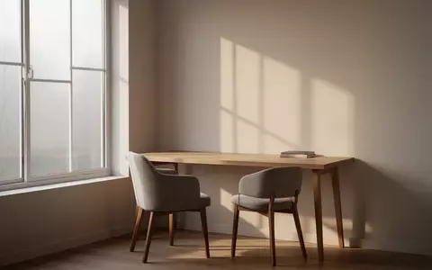 Ein leerer, minimalistischer Arbeitsplatz in einem Homeoffice mit einem Holztisch und einem Stuhl bei natürlichem Licht. - Foto: über boerse-global.de