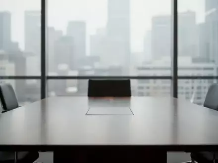 Ein minimalistischer Konferenzraum mit Blick auf eine Stadt, der eine neutrale, professionelle Atmosphäre vermittelt. - Foto: über boerse-global.de