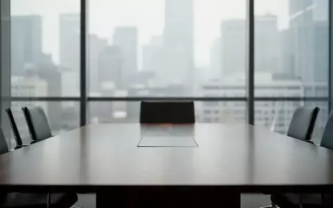 Ein minimalistischer Konferenzraum mit Blick auf eine Stadt, der eine neutrale, professionelle Atmosphäre vermittelt. - Foto: über boerse-global.de