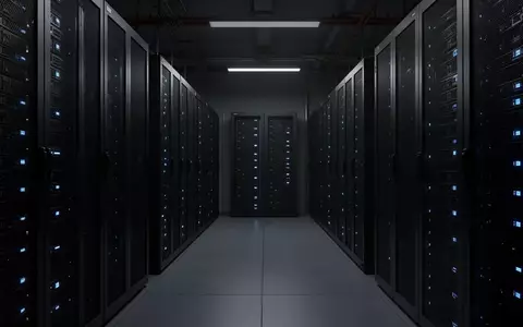 Dunkler, minimalistischer Serverraum mit symmetrischen Metallschränken und blauen Statusleuchten in einer Industrieumgebung. - Foto: über boerse-global.de