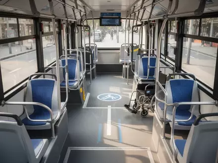 Leerer, barrierefreier Innenraum eines modernen Stadtbusses mit großzügigen Flächen für Mobilitätshilfen. - Foto: über boerse-global.de