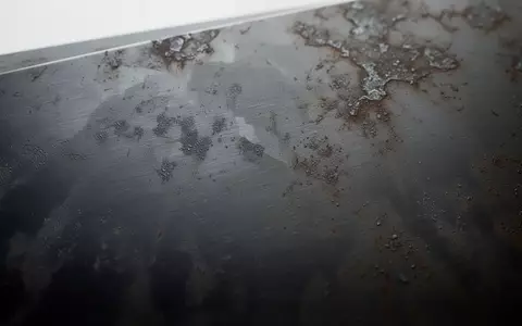 Nahaufnahme einer dunklen Metalloberfläche mit subtilen Abnutzungsspuren und ungleichmäßiger Textur bei diffusem Licht. - Foto: über boerse-global.de